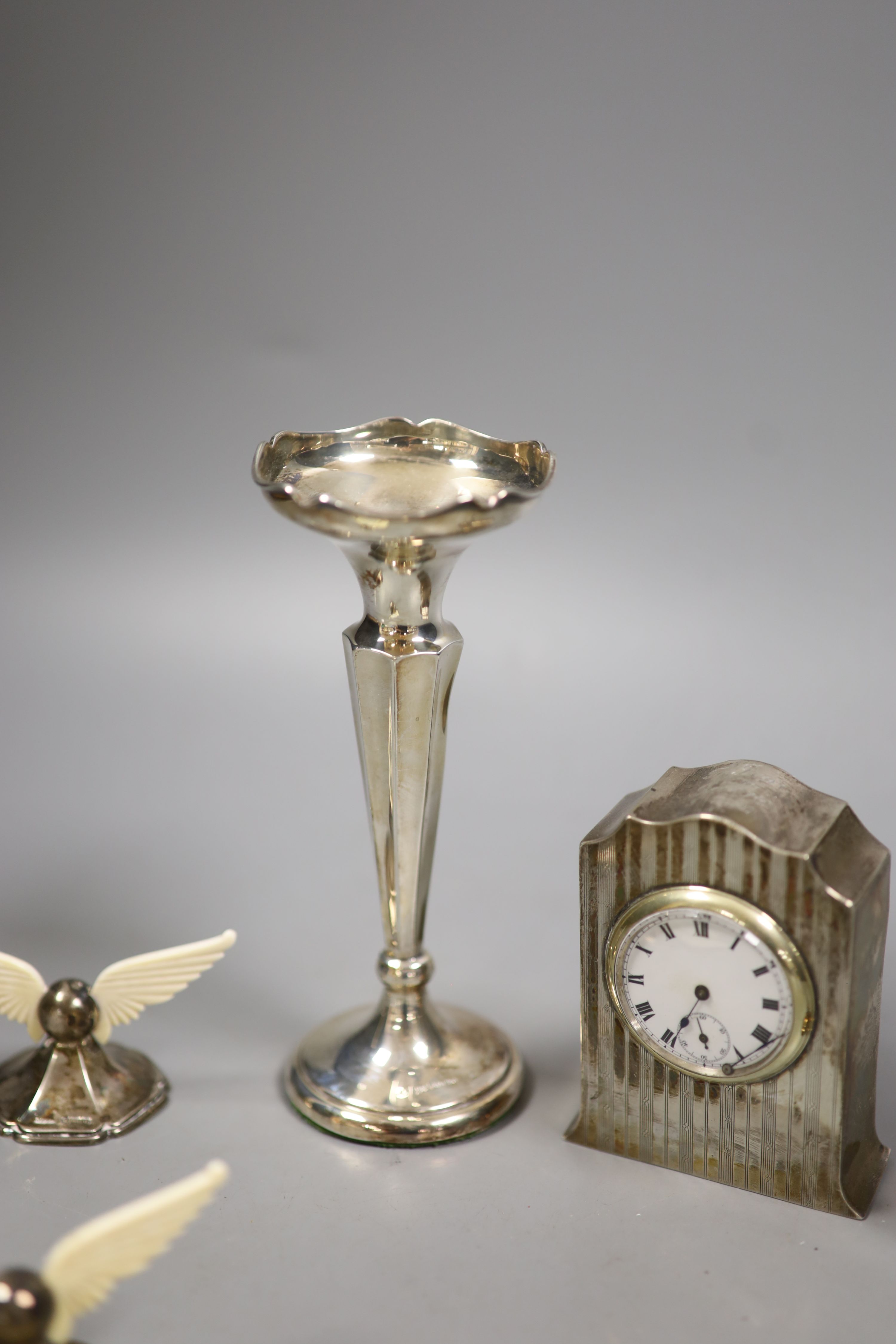 A George V silver cased bedside timepiece, a silver and ivory perpetual calendar and a pair of silver and ivory knife rests